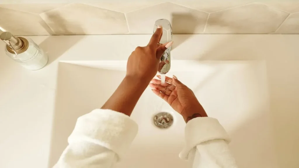 person in white robe washing hands